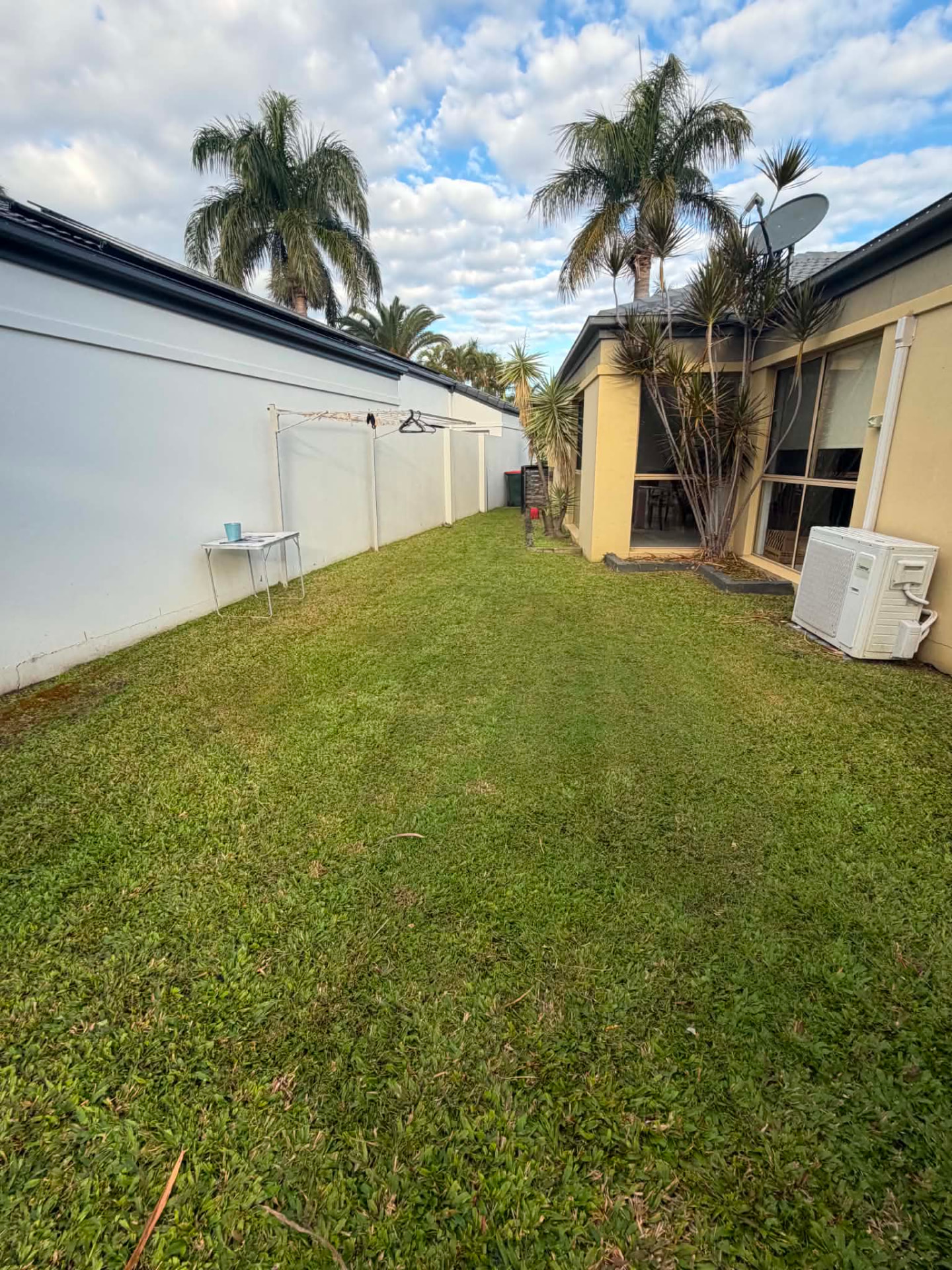 Freshly mown backyard lawn beside a house