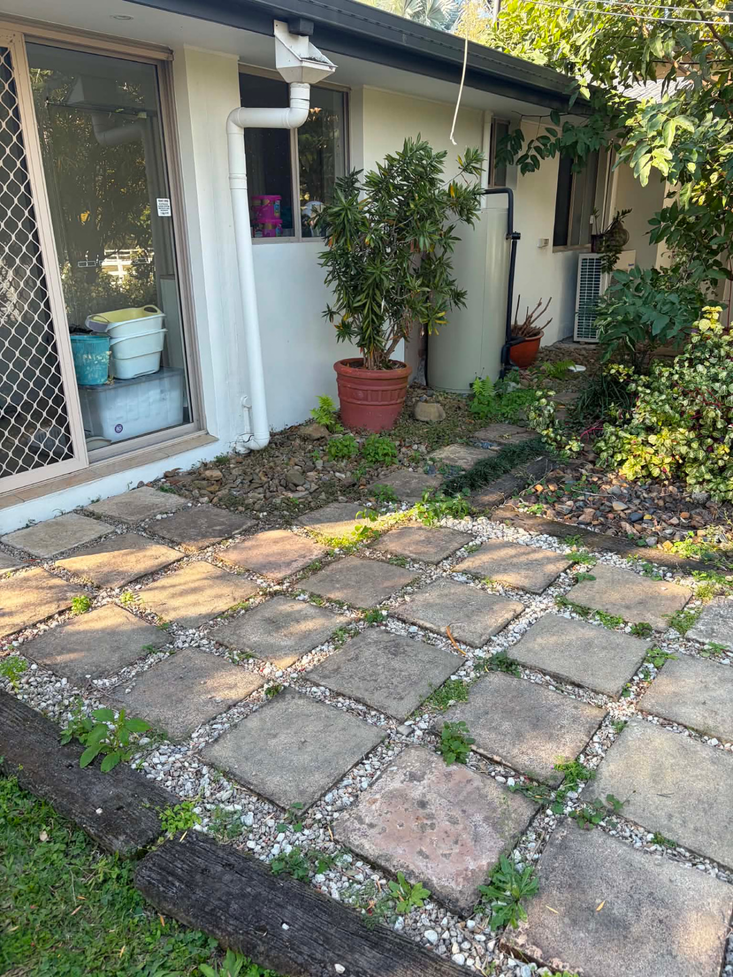 Paver courtyard with weeds growing between the stones
