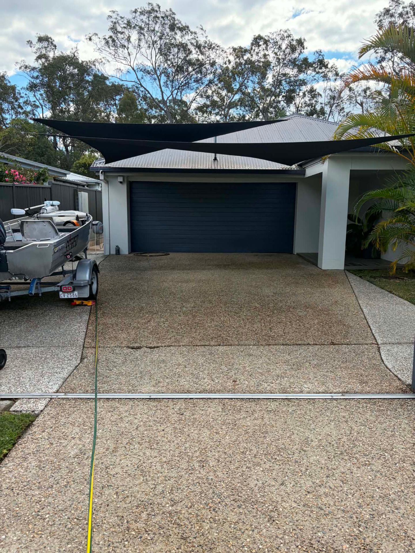 Same driveway looking clean and restored after pressure washing